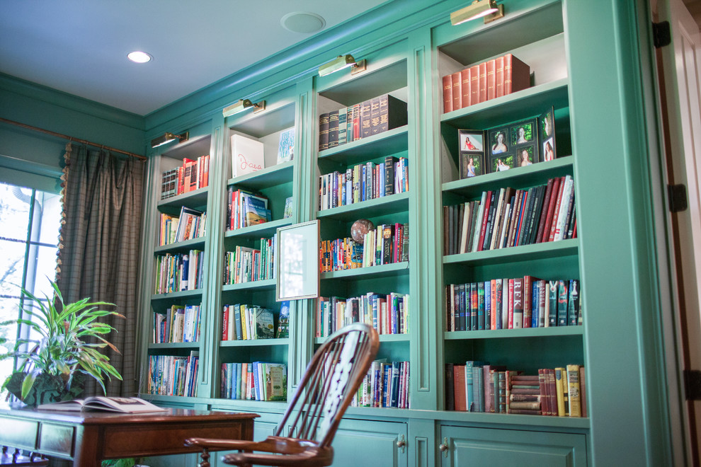 Exempel på ett stort klassiskt arbetsrum, med ett bibliotek, gröna väggar och ett fristående skrivbord