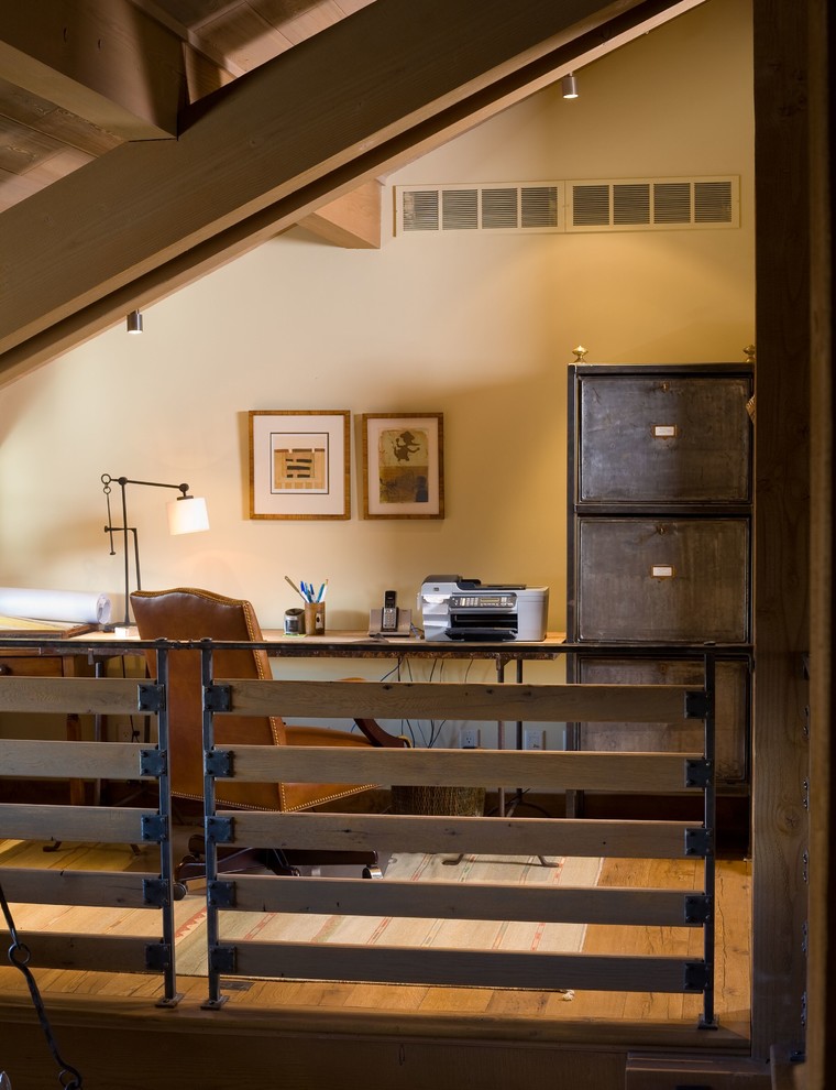 Diseño de despacho rural grande sin chimenea con paredes blancas, suelo de madera en tonos medios y escritorio independiente