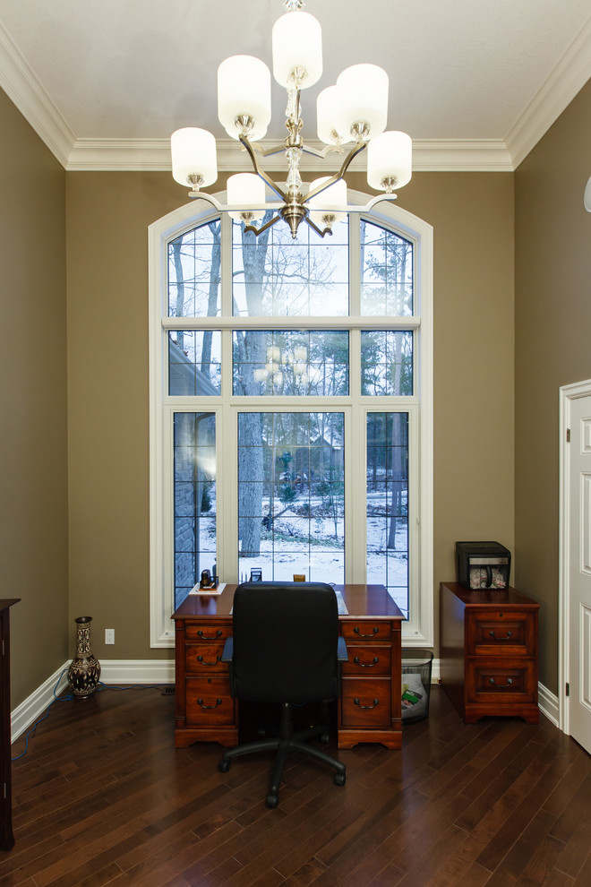 This is an example of a medium sized classic home office with brown walls and medium hardwood flooring.