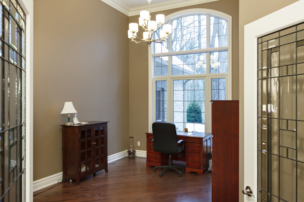 Mittelgroßes Klassisches Arbeitszimmer mit brauner Wandfarbe und braunem Holzboden