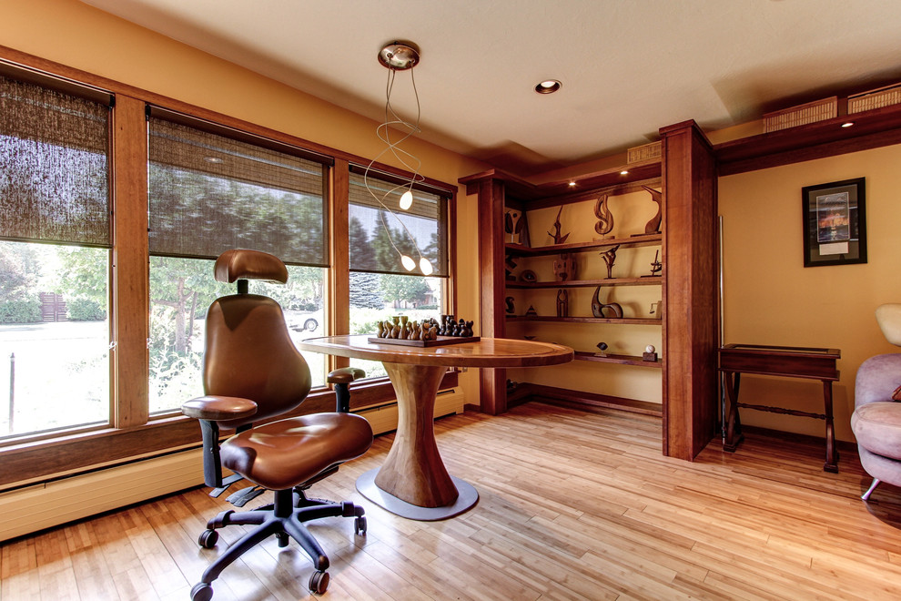 ローリーにある広いトラディショナルスタイルのおしゃれなホームオフィス・書斎 (無垢フローリング、自立型机、暖炉なし、茶色い床、オレンジの壁) の写真