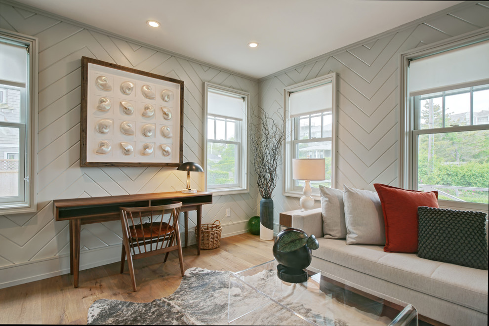 Imagen de despacho costero con paredes grises, suelo de madera en tonos medios y escritorio independiente