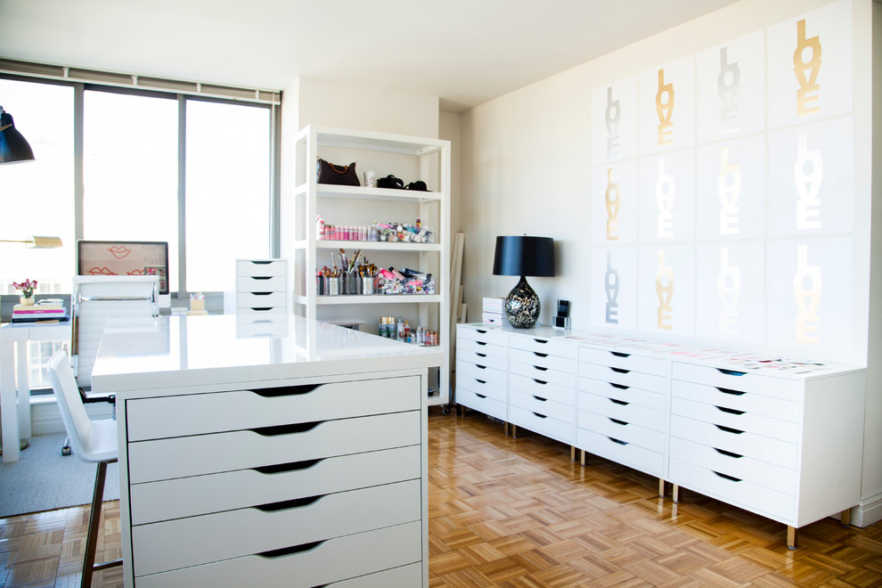 Diseño de estudio actual con suelo de madera en tonos medios, escritorio independiente y paredes blancas