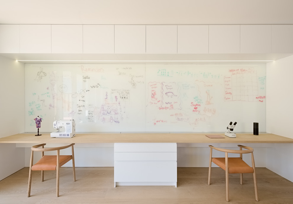 На фото: рабочее место среднего размера в стиле модернизм с белыми стенами, светлым паркетным полом, встроенным рабочим столом и бежевым полом