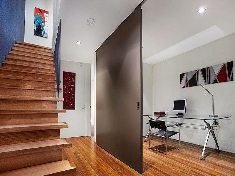 This is an example of a medium sized modern study in Melbourne with a freestanding desk.