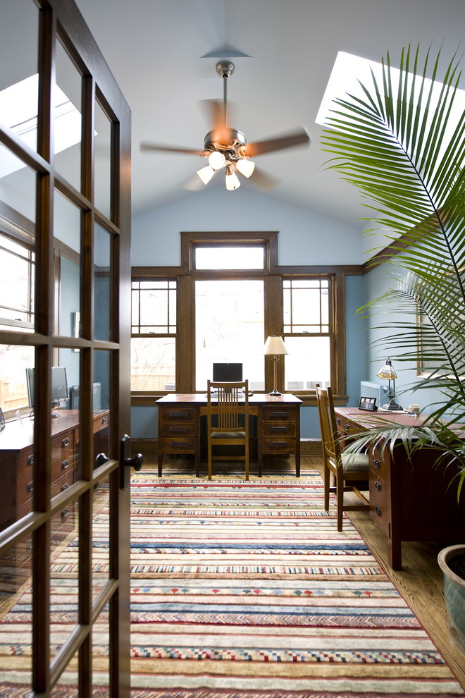Foto di uno studio stile americano con pareti blu, pavimento in legno massello medio e scrivania autoportante