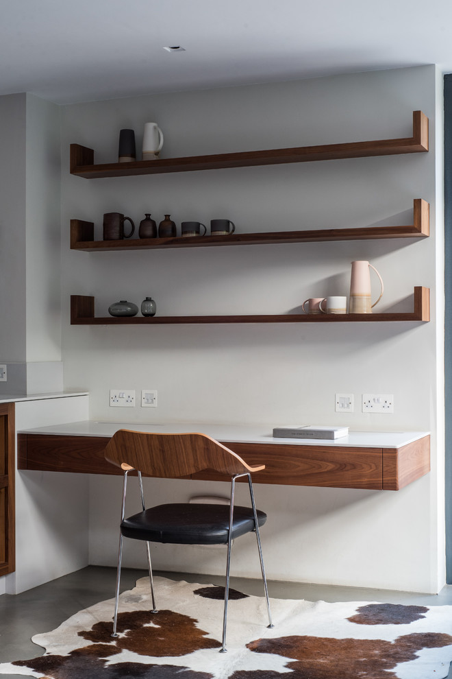 Kleines Modernes Arbeitszimmer mit weißer Wandfarbe, Betonboden, Einbau-Schreibtisch und grauem Boden in London