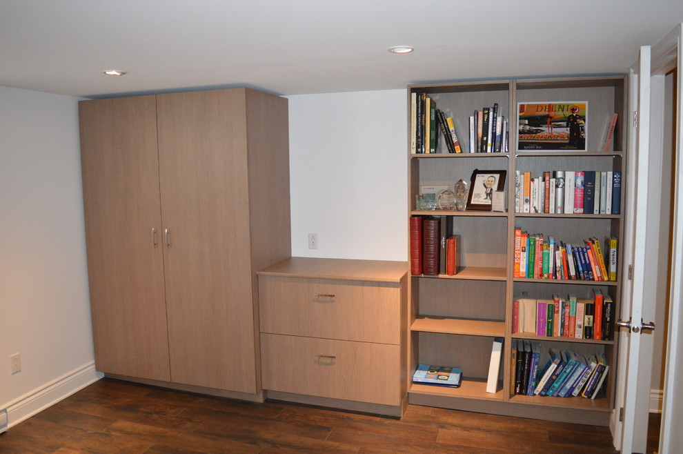 Bild på ett mellanstort funkis hemmabibliotek, med vita väggar, linoleumgolv och ett inbyggt skrivbord