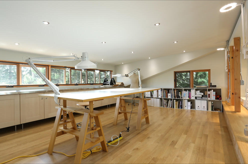Example of a trendy freestanding desk light wood floor home studio design in Portland with white walls