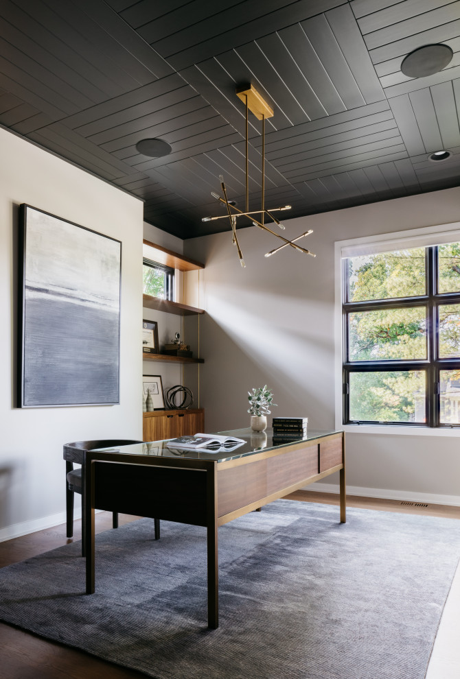 Idee per uno studio contemporaneo con pareti grigie, pavimento in legno massello medio, scrivania autoportante e pavimento marrone