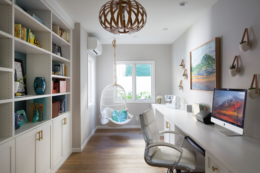 Modelo de despacho clásico renovado con paredes grises, suelo de madera en tonos medios, escritorio empotrado y suelo marrón