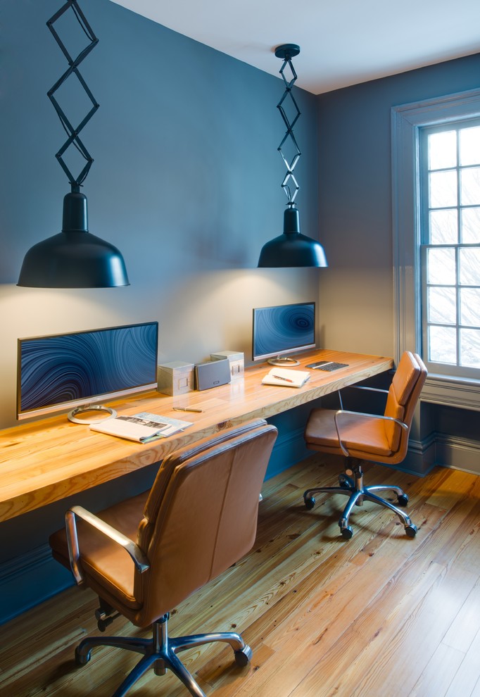 Idéer för att renovera ett eklektiskt arbetsrum, med blå väggar, mellanmörkt trägolv och ett inbyggt skrivbord