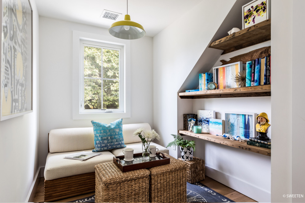 Cette photo montre un petit bureau nature en bois avec une bibliothèque ou un coin lecture, un mur blanc et parquet clair.