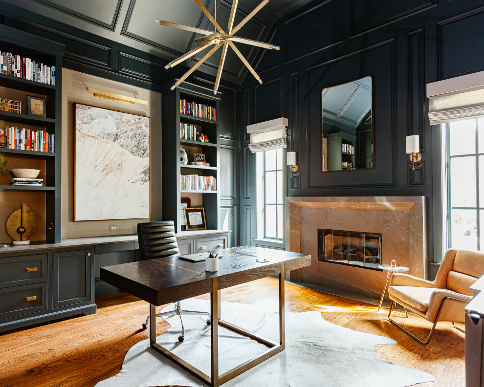 Medium sized classic study in Dallas with green walls, medium hardwood flooring, a standard fireplace, a stone fireplace surround, a freestanding desk, brown floors, a vaulted ceiling and panelled walls.