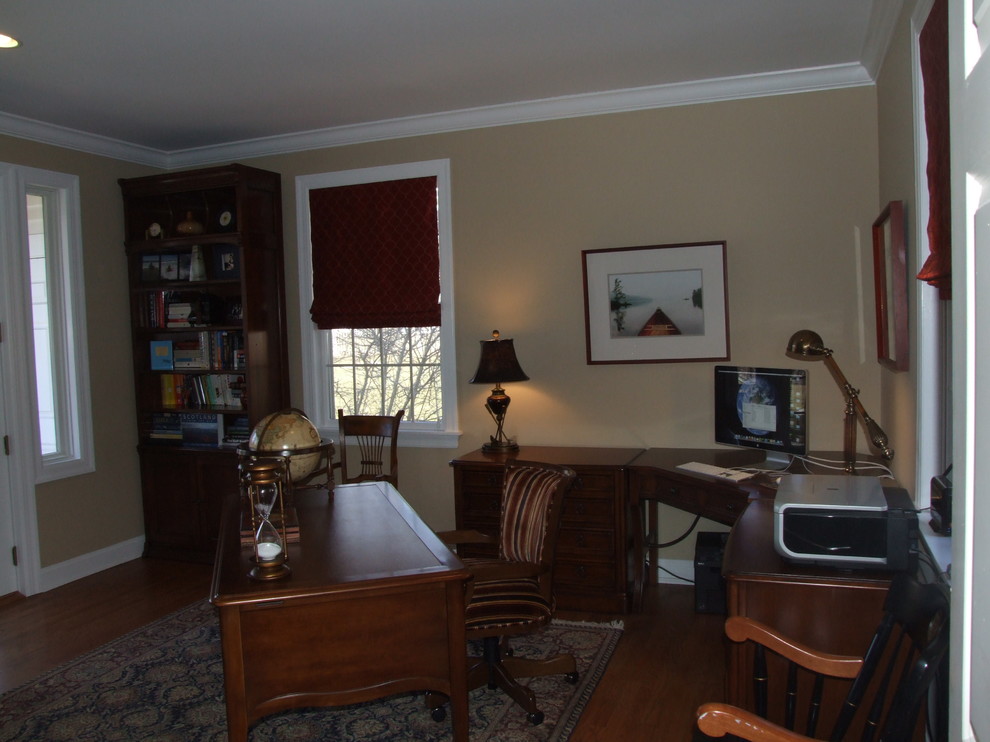 Ejemplo de despacho clásico sin chimenea con paredes beige, suelo de madera en tonos medios y escritorio independiente