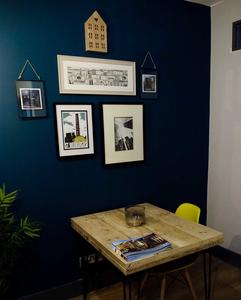 Imagen de despacho industrial grande con paredes azules, suelo de madera en tonos medios, escritorio independiente y suelo beige