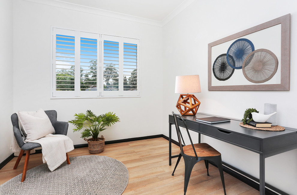 シドニーにある中くらいなトランジショナルスタイルのおしゃれな書斎 (白い壁、淡色無垢フローリング、自立型机、ベージュの床) の写真