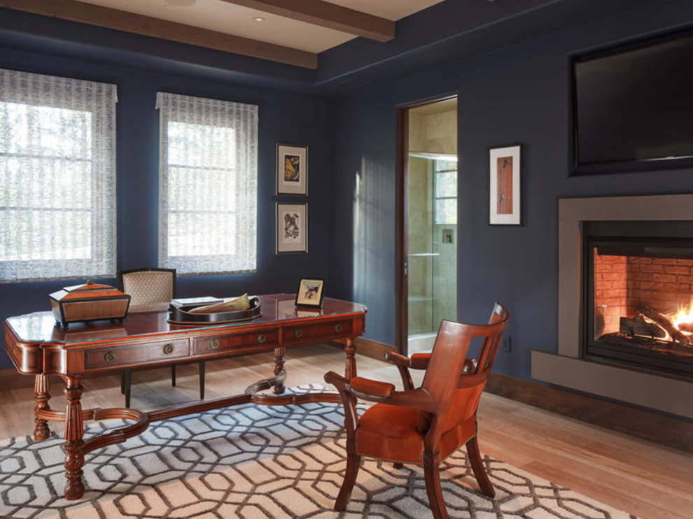 サンフランシスコにある高級な広いコンテンポラリースタイルのおしゃれなホームオフィス・書斎 (青い壁、無垢フローリング、標準型暖炉、漆喰の暖炉まわり、自立型机、茶色い床) の写真