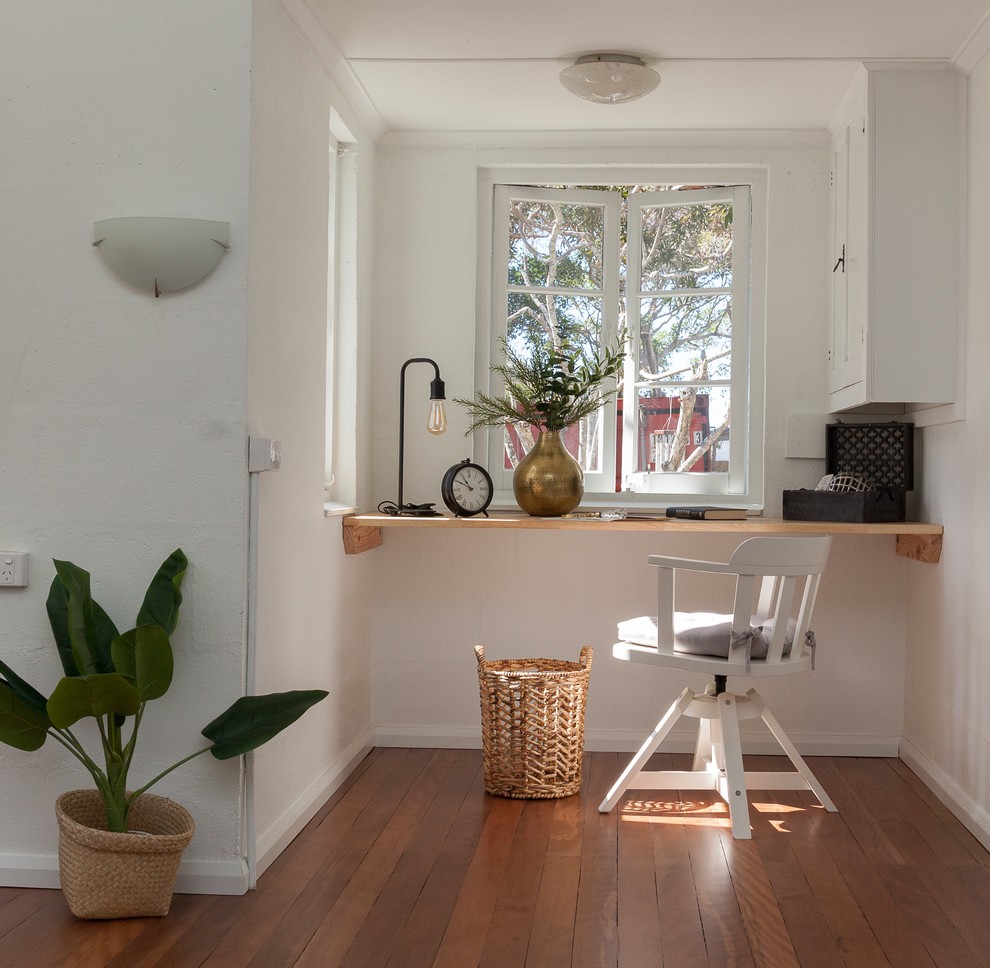 Идея дизайна: кабинет в скандинавском стиле с белыми стенами, коричневым полом, паркетным полом среднего тона и встроенным рабочим столом без камина
