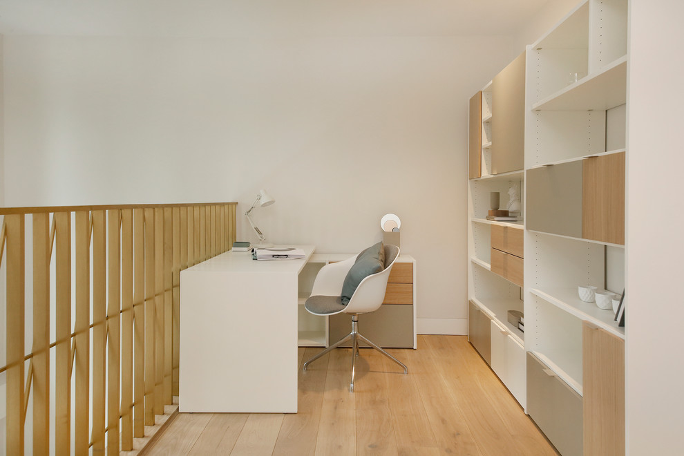 ロンドンにあるコンテンポラリースタイルのおしゃれなホームオフィス・書斎 (白い壁、淡色無垢フローリング、自立型机) の写真