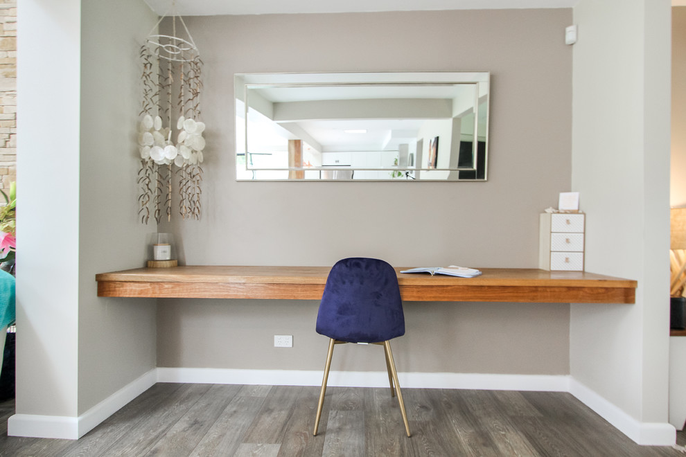 Foto di un piccolo ufficio country con pareti beige, parquet chiaro, scrivania incassata e pavimento grigio
