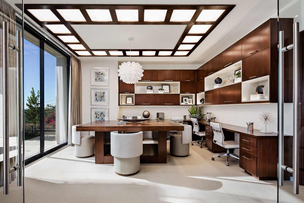 На фото: кабинет в современном стиле с белыми стенами и встроенным рабочим столом