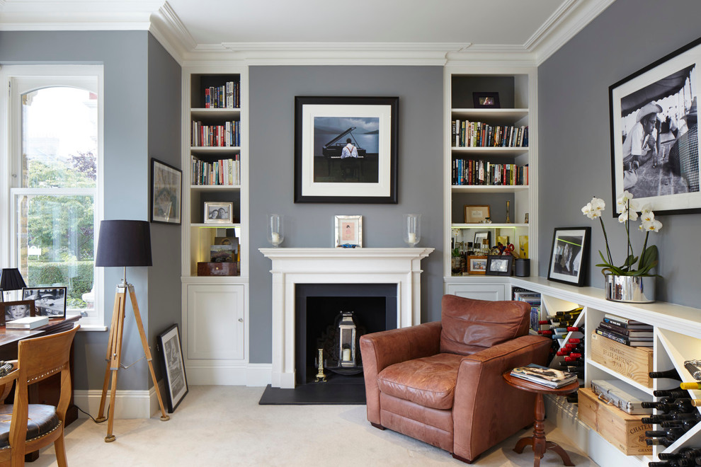 На фото: кабинет в классическом стиле с серыми стенами, стандартным камином и ковровым покрытием с