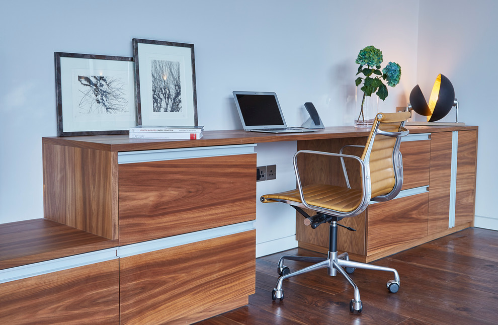 Modernes Arbeitszimmer mit weißer Wandfarbe, braunem Holzboden und Einbau-Schreibtisch in Devon