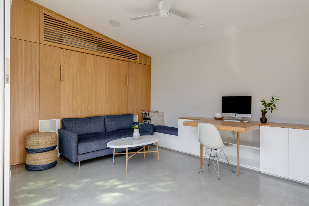 Inspiration för små moderna hemmastudior, med vita väggar, betonggolv, ett inbyggt skrivbord och grått golv