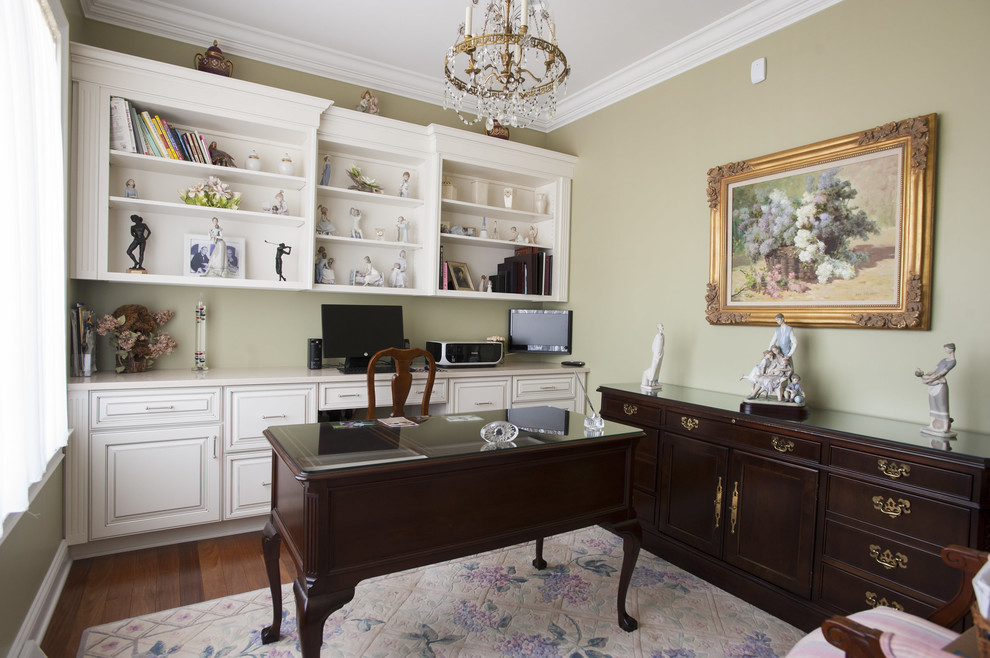 Imagen de despacho tradicional con suelo de madera oscura y escritorio independiente
