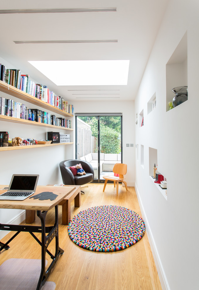 Ejemplo de despacho contemporáneo pequeño con paredes blancas, suelo de madera en tonos medios y escritorio independiente