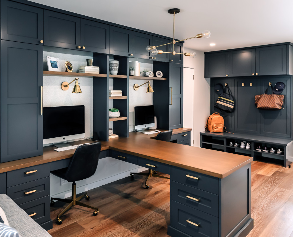 Diseño de despacho clásico renovado con paredes grises, suelo de madera en tonos medios, escritorio empotrado y suelo marrón