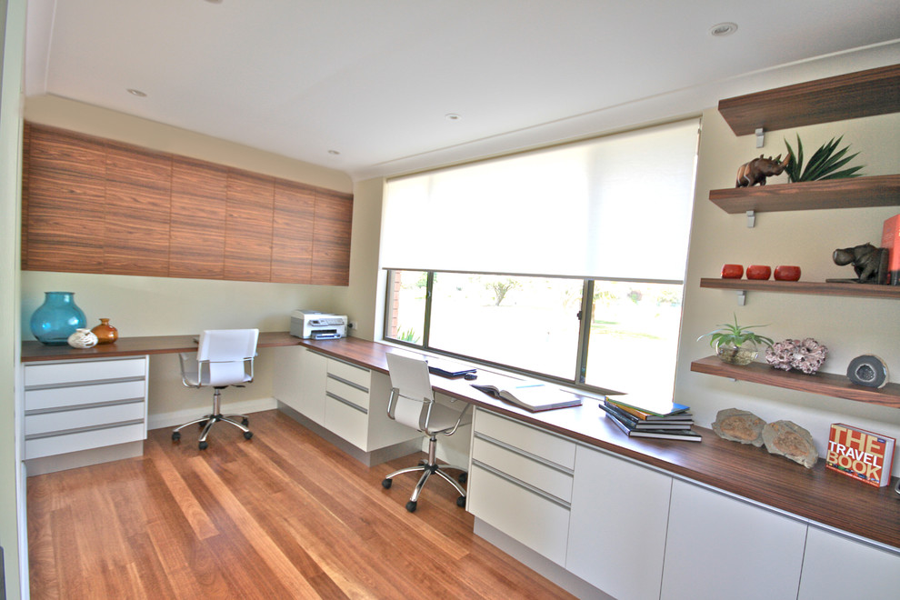 Idee per un ufficio design di medie dimensioni con pareti bianche, pavimento in legno massello medio e scrivania incassata