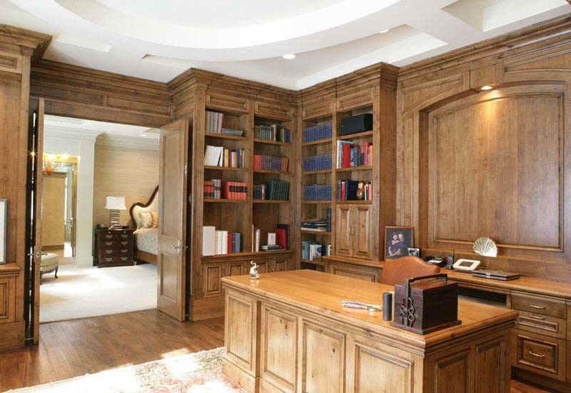 Ejemplo de despacho tradicional sin chimenea con paredes marrones y suelo de madera oscura