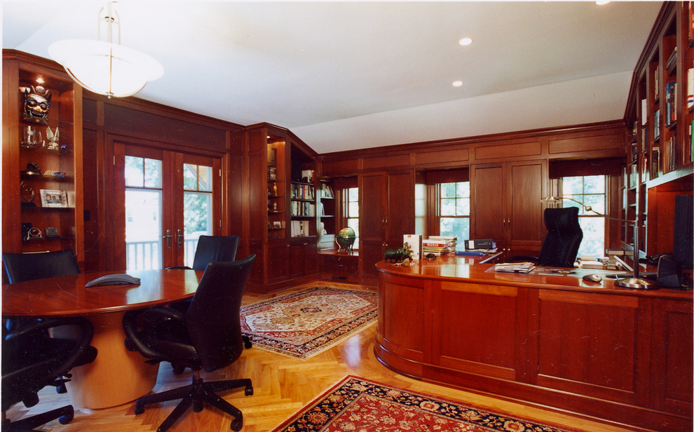 На фото: большой кабинет в классическом стиле с полом из ламината и встроенным рабочим столом с