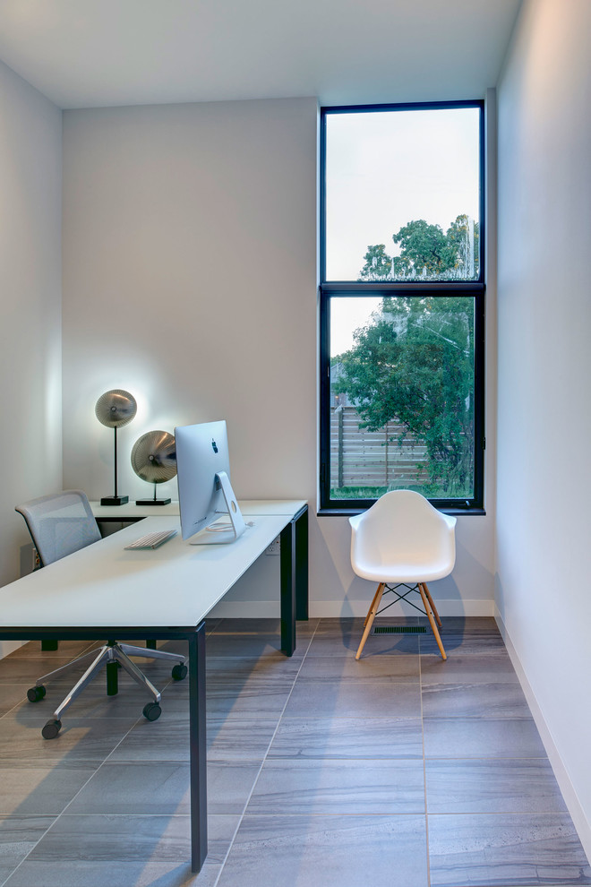 Kleines Mid-Century Arbeitszimmer ohne Kamin mit weißer Wandfarbe und freistehendem Schreibtisch in Cedar Rapids