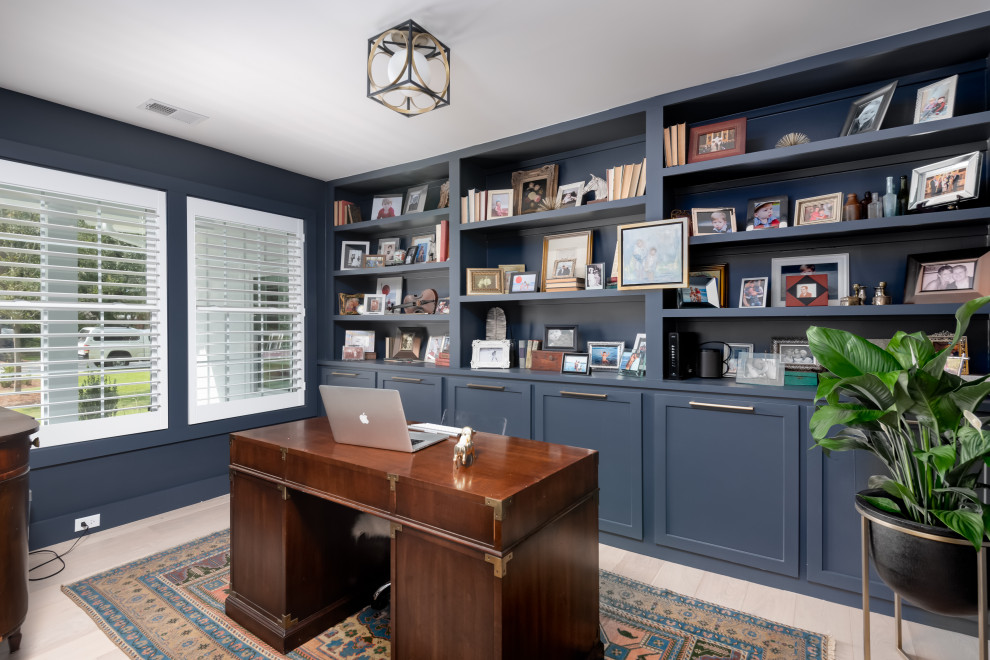 Foto de despacho clásico renovado de tamaño medio con paredes azules, suelo de madera clara, escritorio independiente y suelo beige
