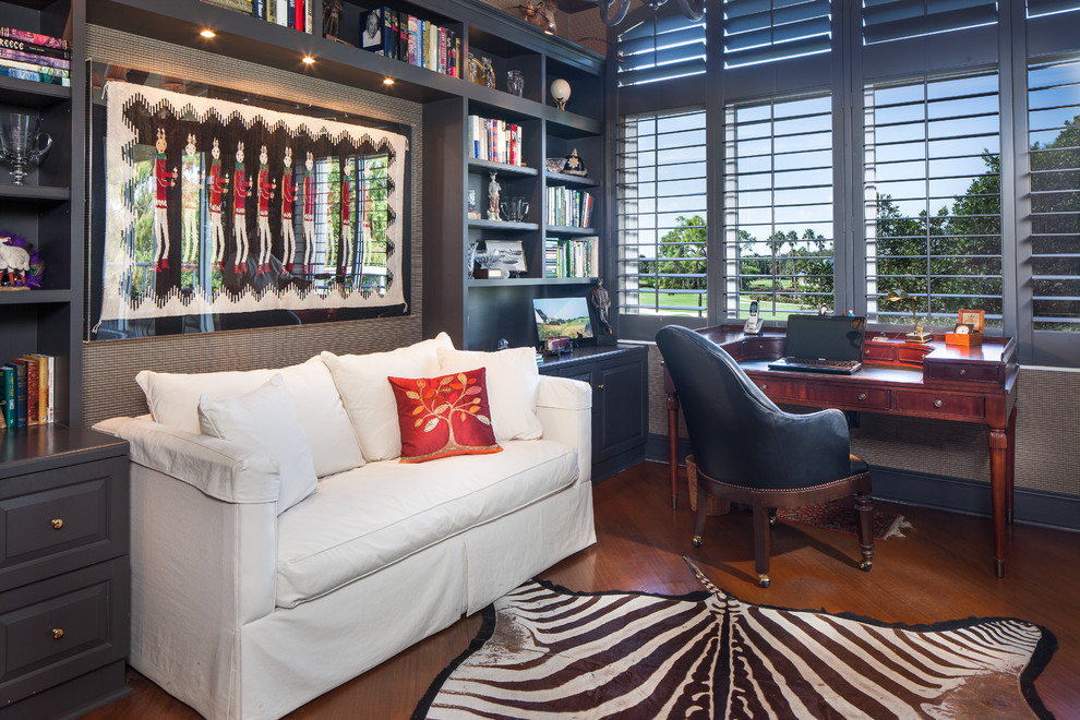 Classic study in Miami with dark hardwood flooring, no fireplace, a freestanding desk and blue walls.