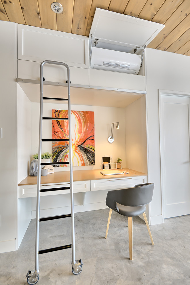 Inspiration för små klassiska arbetsrum, med vita väggar, betonggolv och ett inbyggt skrivbord