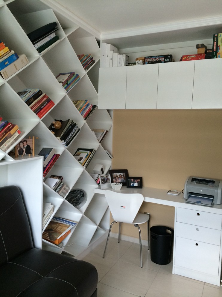 Bild på ett funkis hemmabibliotek, med beige väggar och ett inbyggt skrivbord