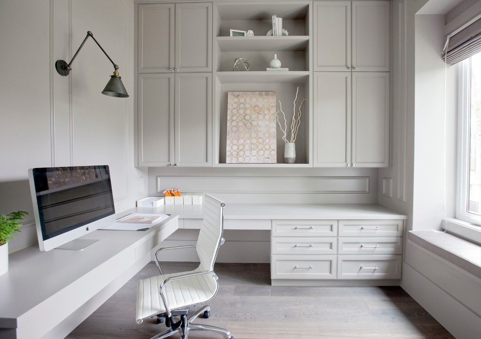 Photo of a classic study in Vancouver with beige walls, light hardwood flooring, a built-in desk and beige floors.