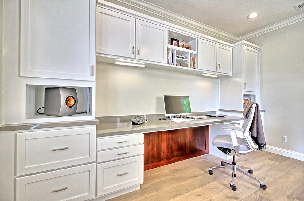 Cette image montre un grand bureau traditionnel avec un mur gris, parquet clair, aucune cheminée et un bureau intégré.