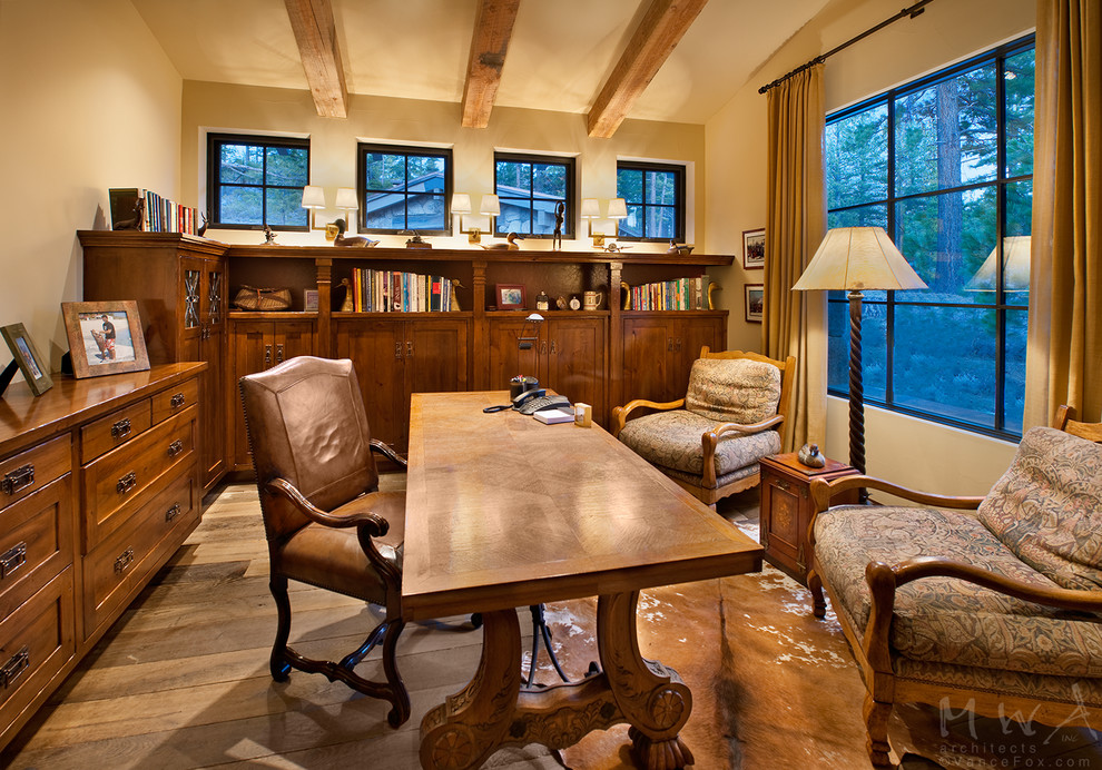 Cette photo montre un grand bureau montagne avec un mur beige, un sol en bois brun, un bureau indépendant et un sol marron.
