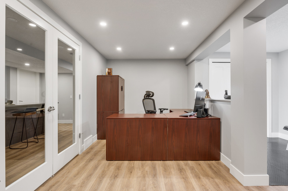 Idéer för mellanstora funkis arbetsrum, med grå väggar, vinylgolv, ett fristående skrivbord och brunt golv