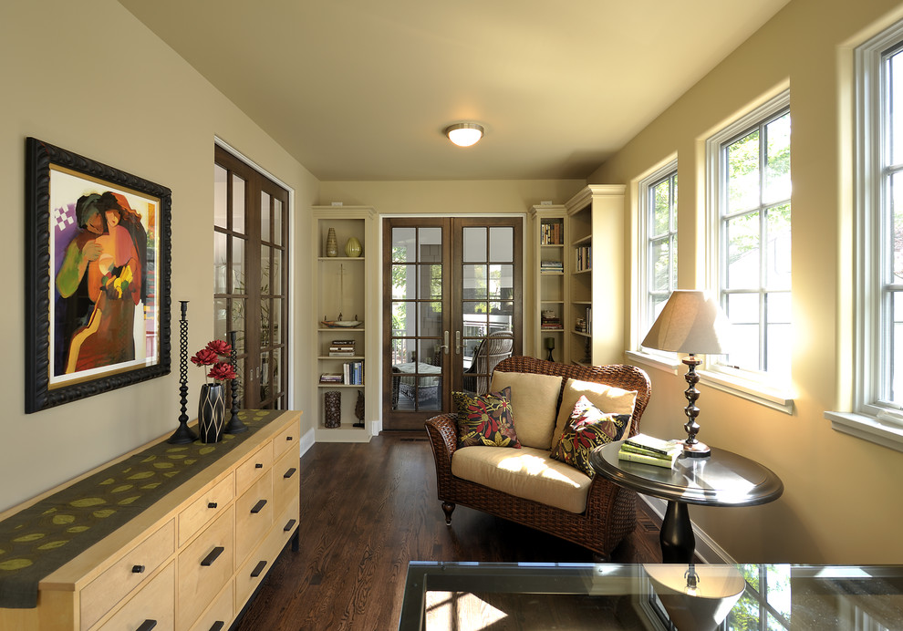 Foto de despacho clásico con paredes beige, suelo de madera oscura y escritorio independiente