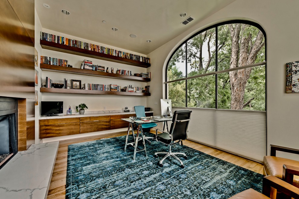 Large classic study in Dallas with grey walls, medium hardwood flooring, a ribbon fireplace, a wooden fireplace surround and a freestanding desk.