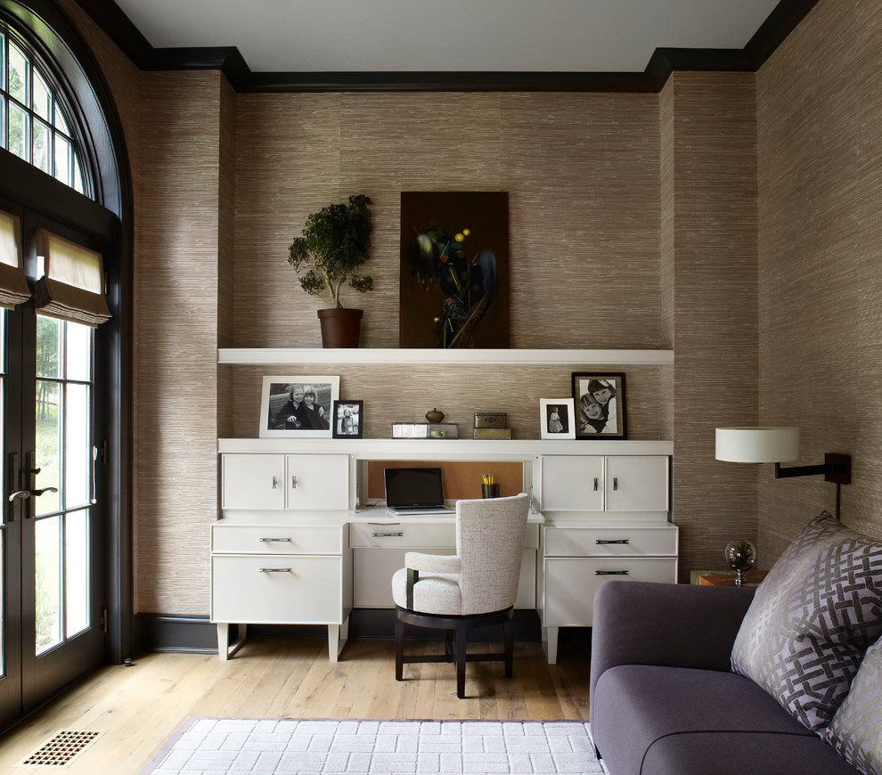 Foto di uno studio minimal con scrivania autoportante, parquet chiaro e pavimento beige