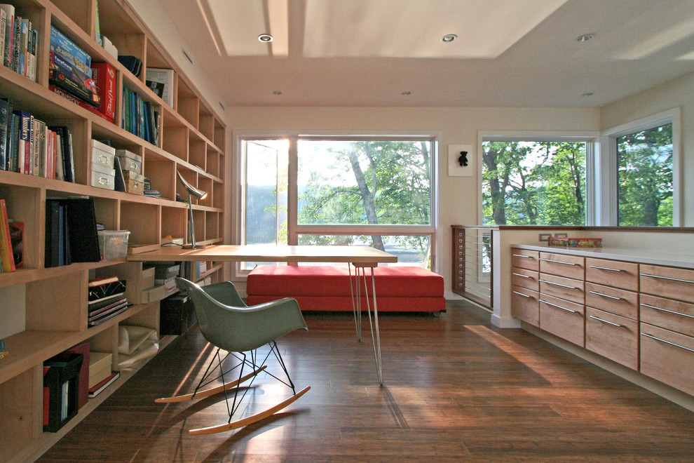 Diseño de despacho minimalista con paredes beige, suelo de madera oscura y escritorio empotrado