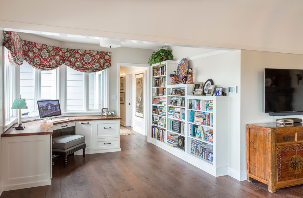 Inspiration för ett mellanstort vintage arbetsrum, med ett bibliotek, beige väggar, mellanmörkt trägolv, ett inbyggt skrivbord och brunt golv