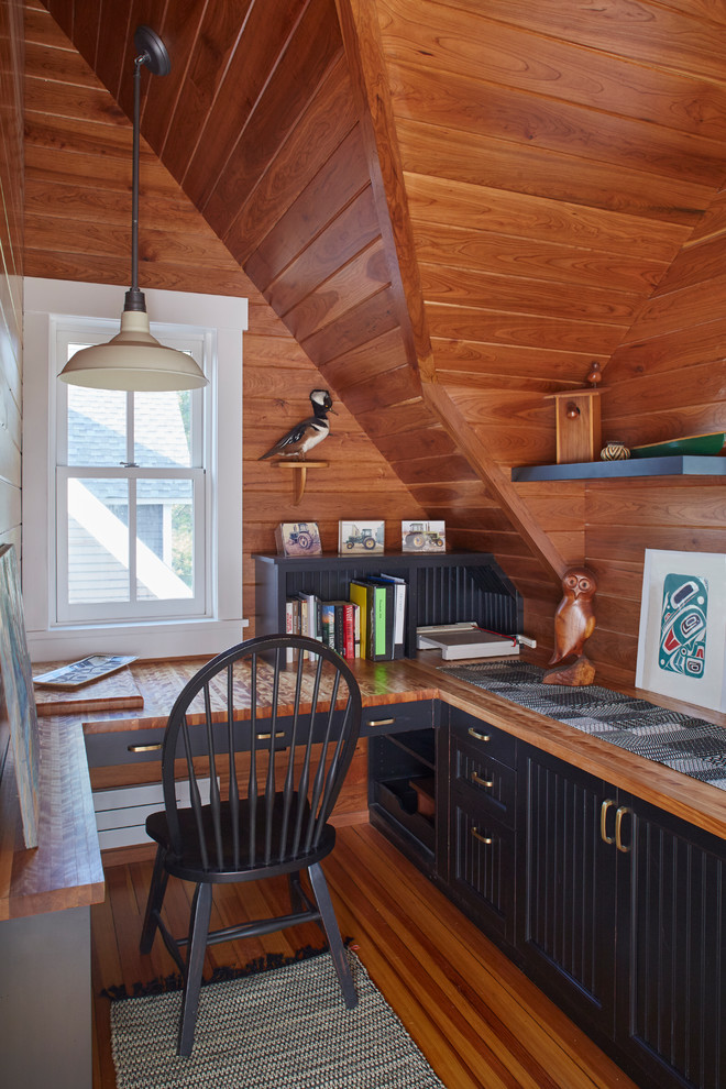 Rural study in Minneapolis with medium hardwood flooring, a built-in desk, brown walls and brown floors.